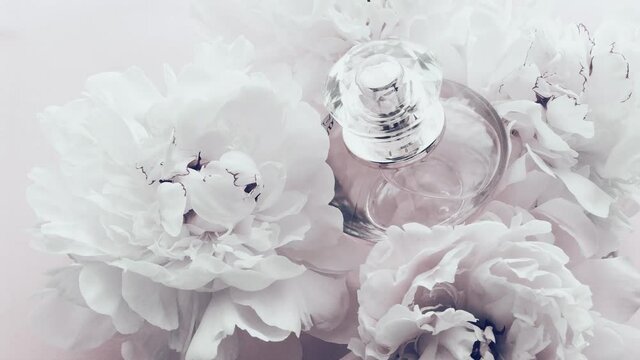 White perfume bottle with peony flowers, chic fragrance scent as luxury cosmetic, fashion and beauty product background, stock footage