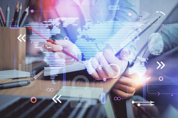 Multi exposure of hands making notes with world map hologram and data theme icons. Concept of global computer data.