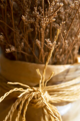 DIY & Interior décor concept of Decoration golden dried grass flower on blurred background at café restaurant or coffee shop with bright sunlight & sun rays from window wall, selective soft focus