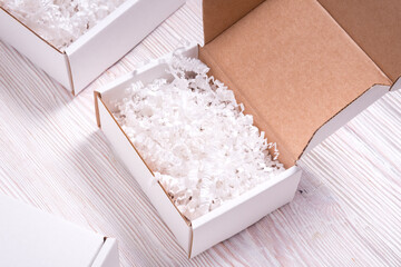 Shredded paper filler in cardboard box on wooden table