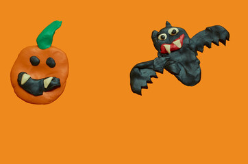 Children's crafts made of plasticine. Halloween. Bat and pumpkin