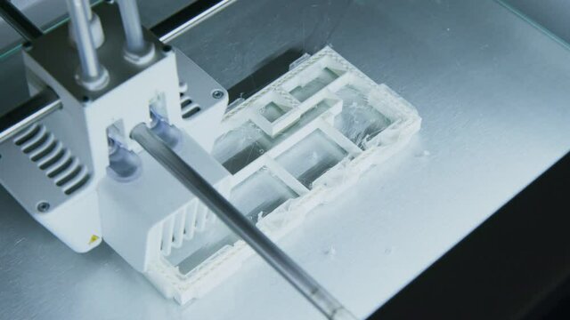 3D printer working on printing an architects building plan in office, Modern Day Technology