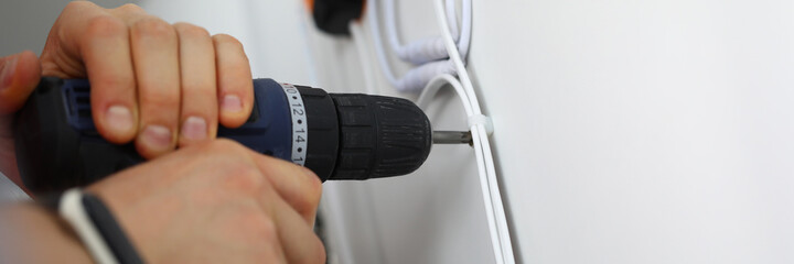 Man holds hammer drill in his hands and drills hole. Renovation service concept