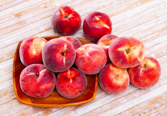 Fototapeta na wymiar Delicious ripe peaches fruit on wooden surface close up