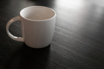 Coffee mug and mobile phone on the table closeup