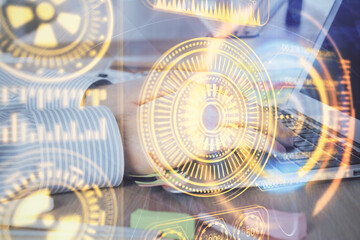 Technology theme hologram with man working on computer on background. High tech concept. Double exposure.