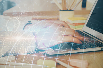Multi exposure of world map hologram with man working on computer on background. Concept of worldwideweb.