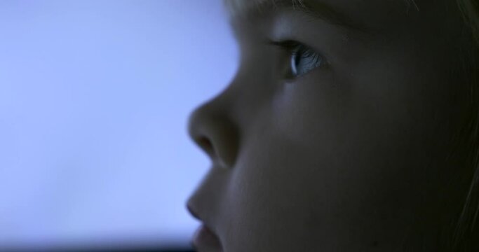 Close-up Child Face. Boy Watches Video Movie on Computer Monitor Screen. Natural Candid Reaction Emotions