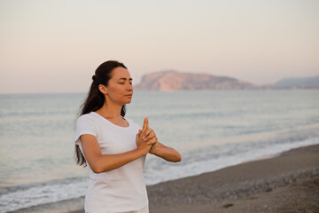 Female practicing yoga and meditation at the beach