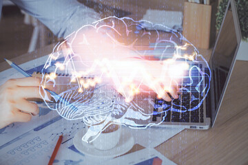 Businessman with computer background with brain theme hologram. Concept of brainstorm. Multi...
