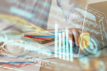 Technology theme hologram with man working on computer on background. High tech concept. Multi exposure.