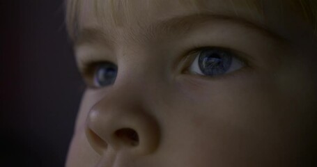 Close-up Child Blue Eyes. Reflection Computer Monitor TV Screen. Natural Candid Reaction Emotions. Boy Watches Action Video Movie