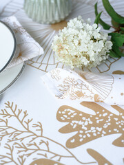 Table setting. Flowers, plates, bright tablecloth with print