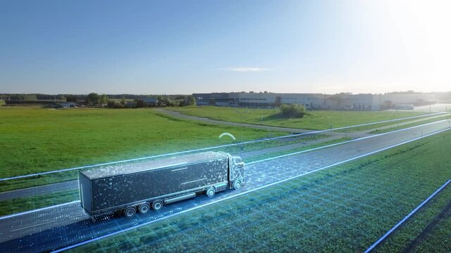 Advanced High-Tech Concept: Big Semi Truck with Cargo Trailer Drives on the Road is Transformed with Graphics Special Effects Into Digitalized Version of Futuristic Autonomous Truck. Aerial Drone Shot