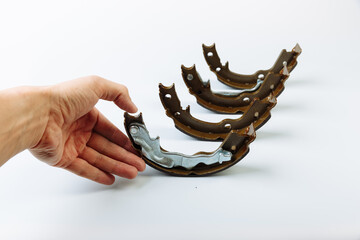 Hand holds brake pad in brake of the car close up view