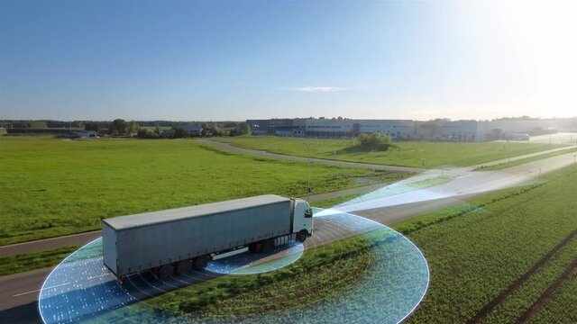 Futuristic Technology Concept: Big Autonomous Semi Truck with Cargo Trailer Drives on the Road with Sensors Scanning. Special Effects of Self Driving Truck Analyzing Freeway. Aerial Drone Shot