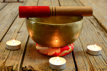 Himalayan Tibetan Singing Bowl yoga bowl  with stick and three candles on wooden table. Meditation...