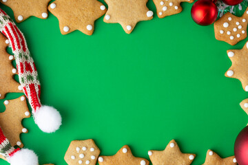 frame for new year Christmas greetings, green background with snowflakes, christmas balls and  gingerbread cookies