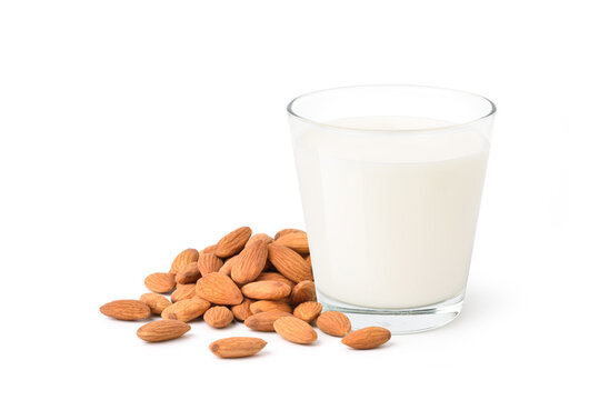 Glass of almond milk with almond seed isolated on white background.