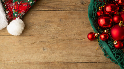  Red Christmas toys in a  green string bag on a brown wood background