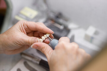 Close-up image of a dental technician working on creating dentures in the laboratory.
