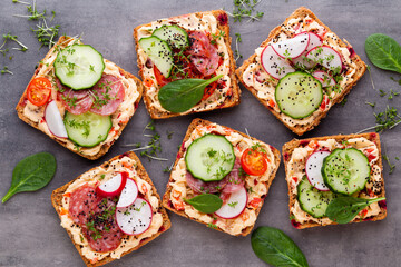 Sandwiches with cream cheese, vegetables and salami.