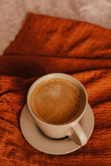 Cozy winter or autumn morning at home. Hot coffee, warm blanket and garland, Swedish hygge concept.