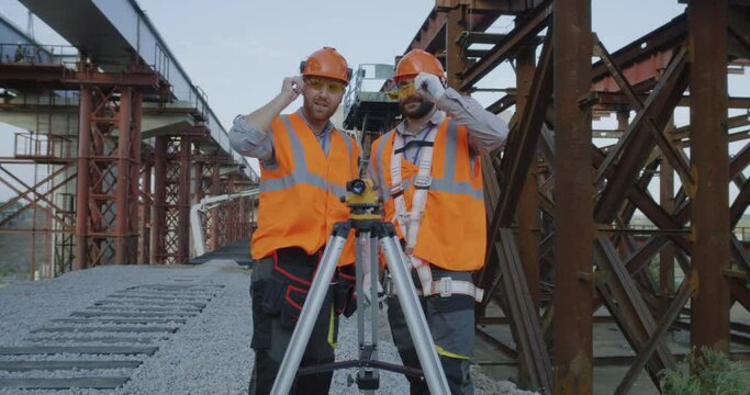 Surveyors measuring construction site with theodolite