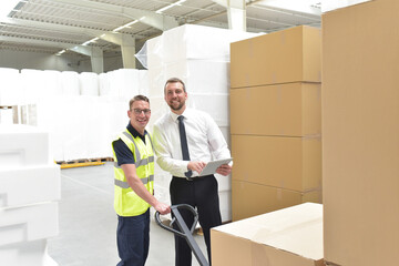 Workerand Manager in a warehouse in the logistics sector - transport and processing of orders in...