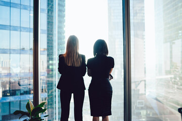 Businesswomen standing near window in workplace