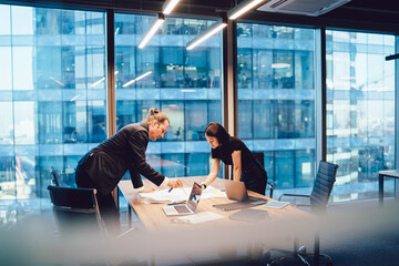 Pensive diverse colleagues working on paper draft in office