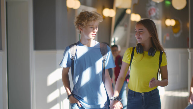 High School Students Couple Walking Together At School Corridor