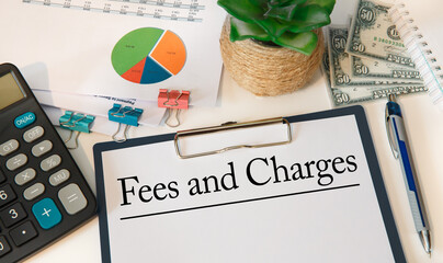 Paper with Fees and Charges on the table, calculator and money