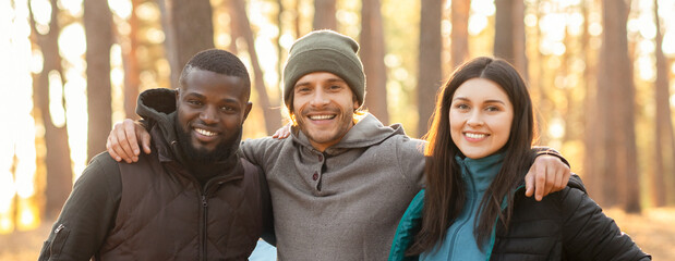 Portrait of three international friends over forest background