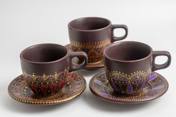 Decorative ceramic painted cup and saucer on white background, close up