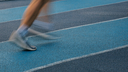 Motion blurred runner's feet on the jogging track