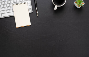 Black office desk table with keyboard, notebook and coffee cup with equipment office supplies. Business and finance concept. Workplace, Top view flat lay with blank copy space. © STPDC Studio