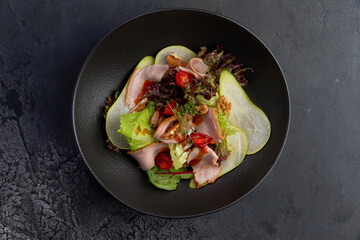 salad with duck pieces and pear slices in a plate