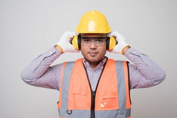 Young asian civil engineer in uniform earmuff helmet safety glasses standing in studio isolated white background. Mechanic home service concept.