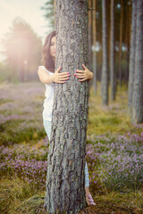 a photo of woman in the forest where the purple heather blooms. copy space. authentic image.