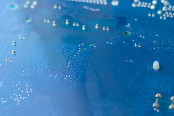Defocused blue computer motherboard closeup background. Selective focus