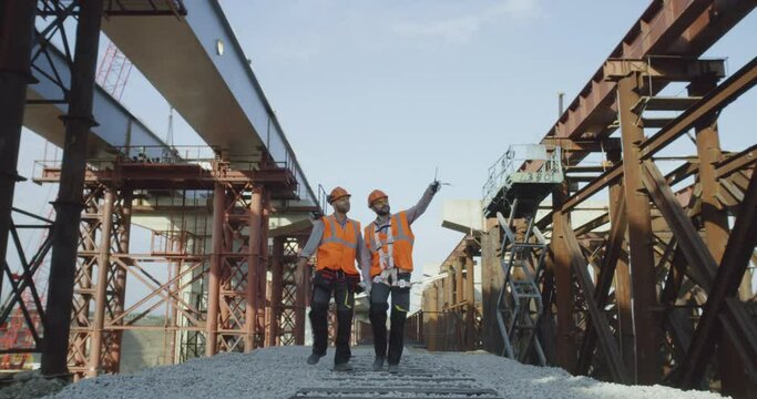 Builders walking near unfinished bridge