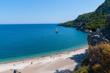 Unidentified people enjoy sea and sand in summer just near ancient city, Olympos, Antalya, Turkey.