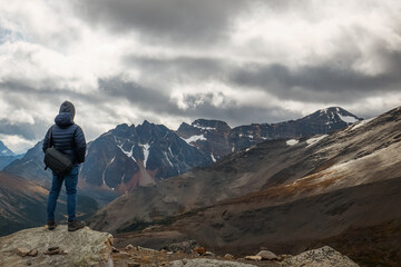 A hiker looking at the mountains from the top of Whistler's Peak in Jasper, Alberta, Canada