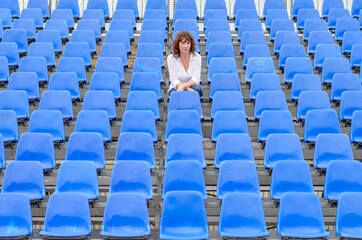 Glum woman sitting in spectator seating