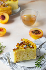 Delicious chiffon cake with custard cream and nectarines with herbal tea and thyme on light concrete background.