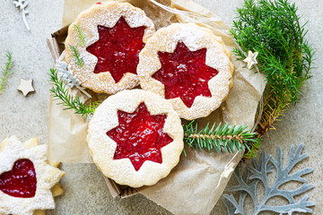 Traditional Austrian cookies with red jam. Christmas or New Year homemade sweet present in gift box. Festive decoration. Stone background. Top view.