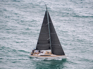 Sailing ship yachts with white sails at opened sea. Aerial - drone view to sailboat in windy...