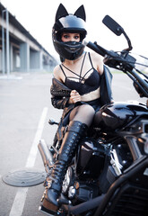 Fototapeta na wymiar sexy girl in a motorcycle helmet sitting on a motorcycle.