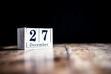 December 27th, 27 December, Twenty Seventh of December - White block calendar on vintage table - Date on dark background